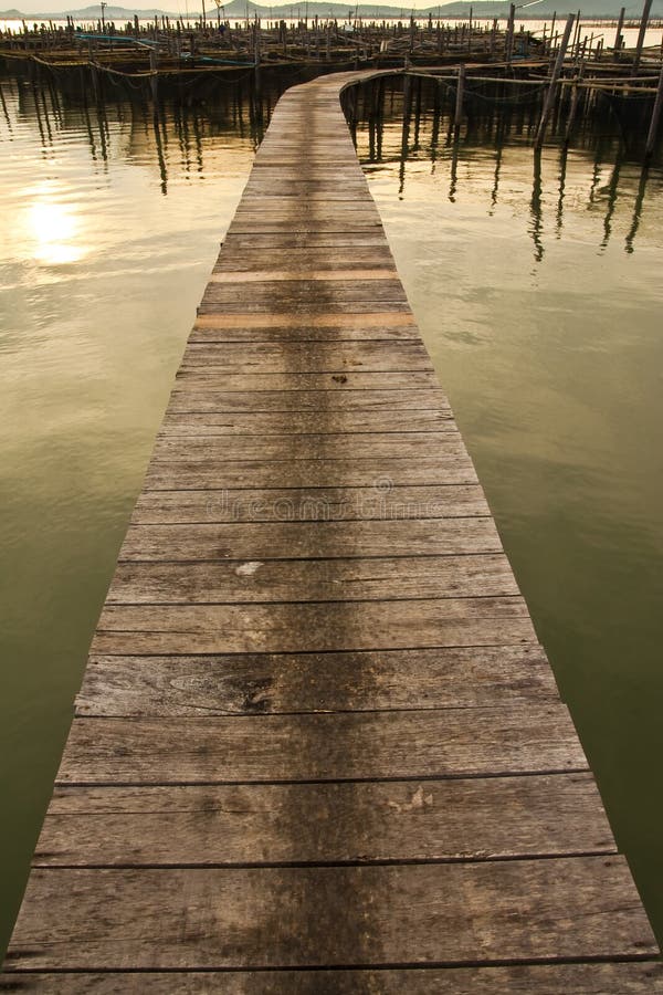 Wood bridge to fisherman house in sea, Thailand