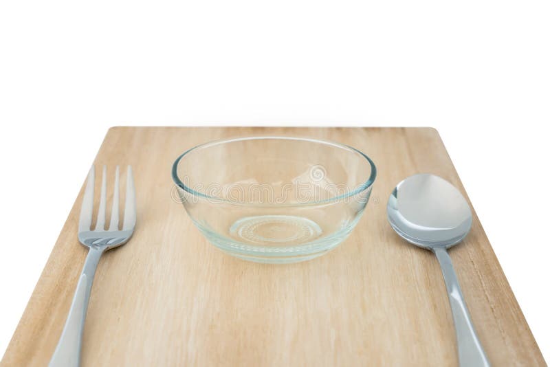 Bowl of cereal with spoon put on wood table near granola in glass