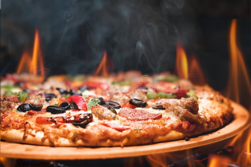 Wood Fired Pizza With Flames. Supreme meat and vegetable pizza on stone in wood-fired oven with open flames stock images