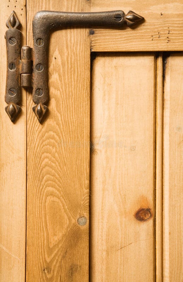 Detail of wooden panelled furniture with iron hinge. Detail of wooden panelled furniture with iron hinge