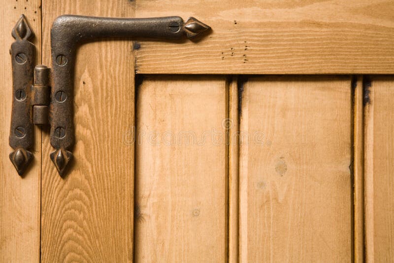 Detail of wooden panelled furniture with iron hinge. Detail of wooden panelled furniture with iron hinge