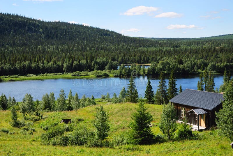 Wood house near blue lake in the middle of taiga forest. royalty free stock photo Wood house near blue lake in the middle of taiga forest. royalty free stock photo