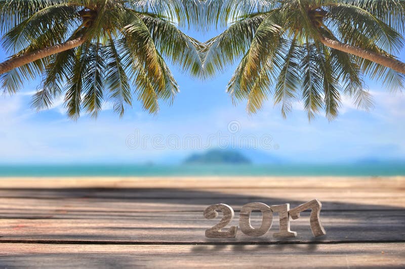 Wood number 2017 on plank on tropical beach background