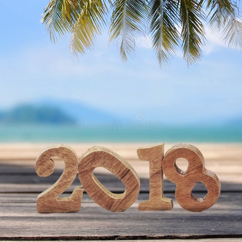 Wood number 2018 on planks on tropical beach background