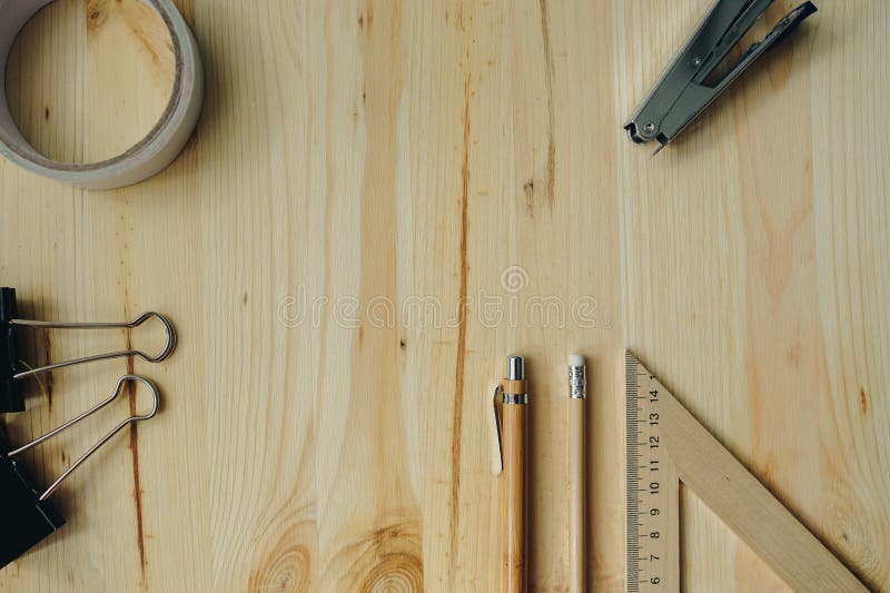 Wood pencil, pen, triangle on the desk in daylight. Office table in daylight