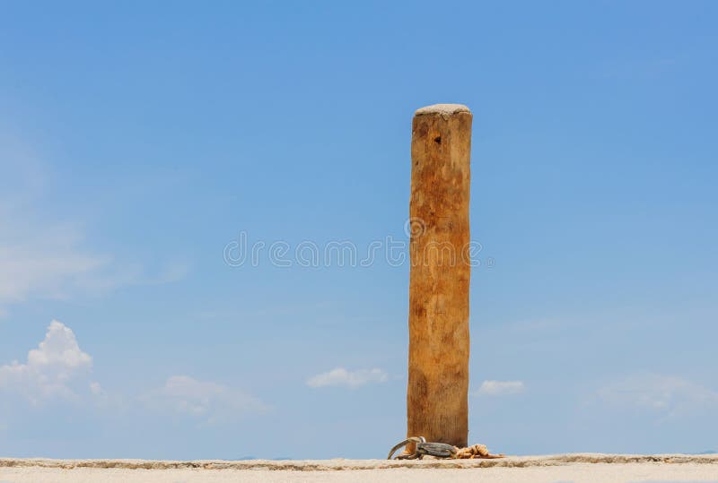 Wood pole for boat rope on blue sky