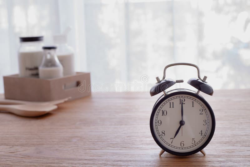 Wood table with glass of milk and retro alarm clock in living room royalty free stock photos Wood table with glass of milk and retro alarm clock in living room royalty free stock photos