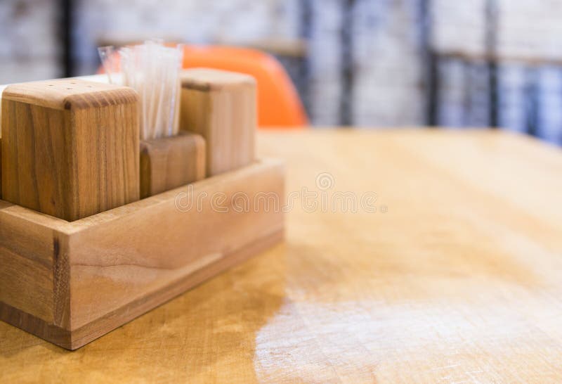 Wood table with salt and pepper shakers in Cafe. blurred background. Perspective view of wooden table corner