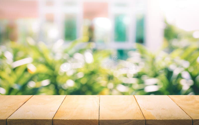 Wood table top on blur of window with garden flower background