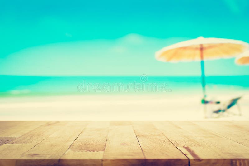 Wood table top on blurred blue sea and white sand beach background