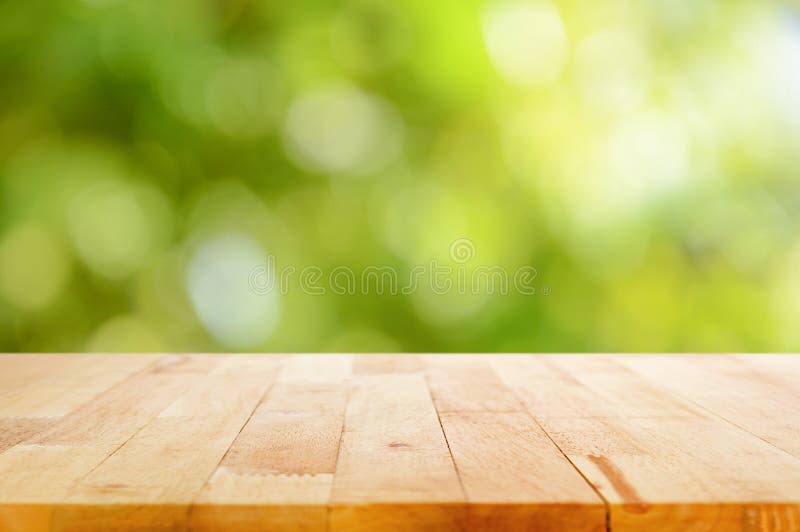 Dřevo stolu na bokeh abstraktní přírodní zelené pozadí.