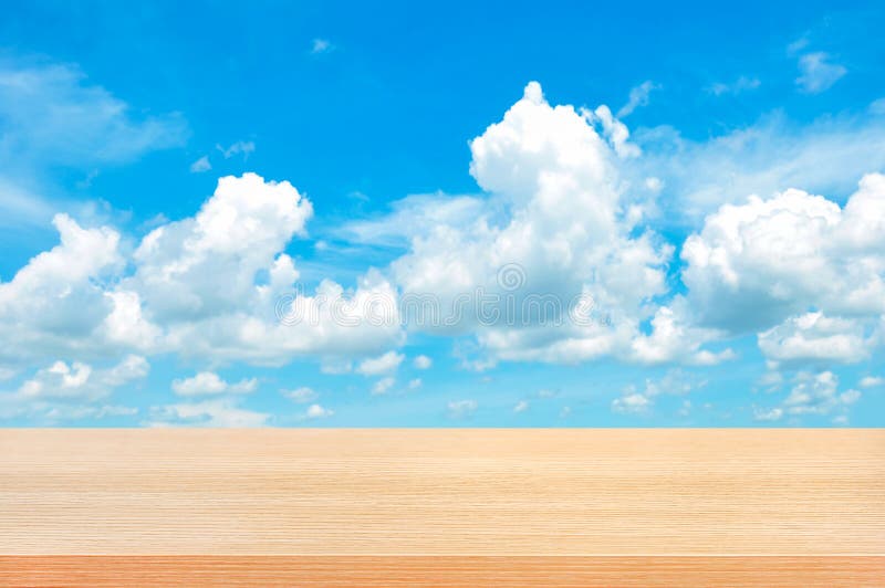 Wood table top on bright summer blue sky background