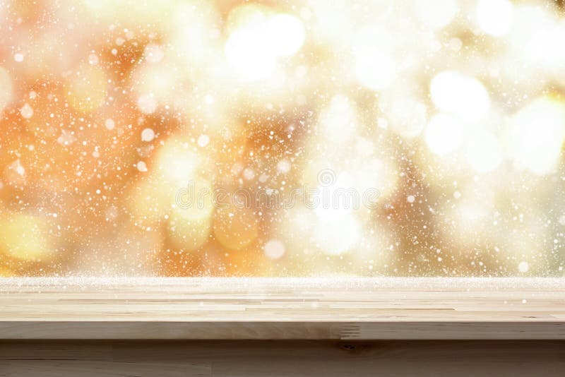 Wood table top on shiny gold bokeh abstract background with snow