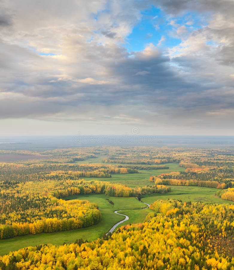 Aerial view of forest river in autumn. Leafs of trees are painted in diferent bright colors. Aerial view of forest river in autumn. Leafs of trees are painted in diferent bright colors.