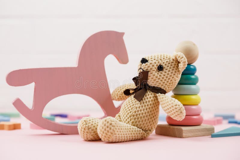 Wooden baby toys on a pastel pink background. numbers, blocks, puzzle shapes, rainbow. Set of accessories for children. royalty free stock images