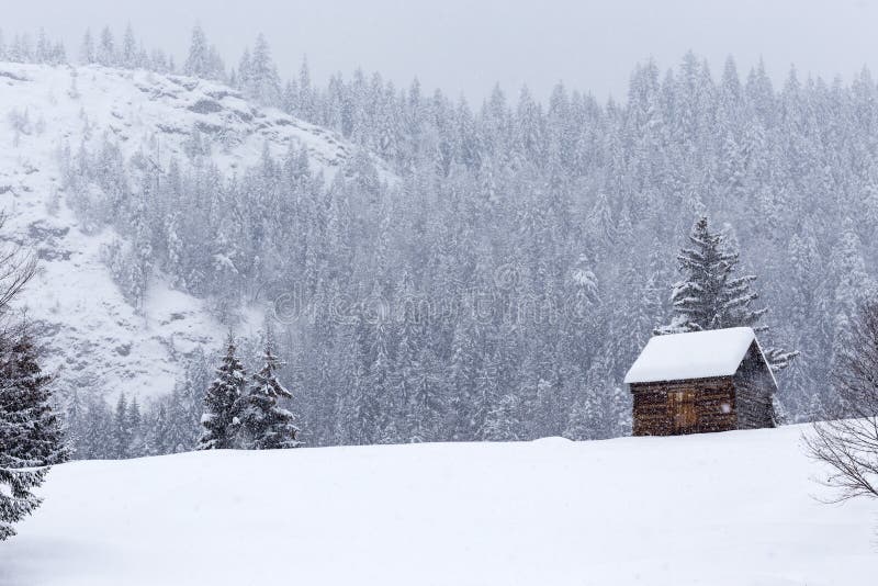 Wooden barn on Romanian mountains at winter with snow