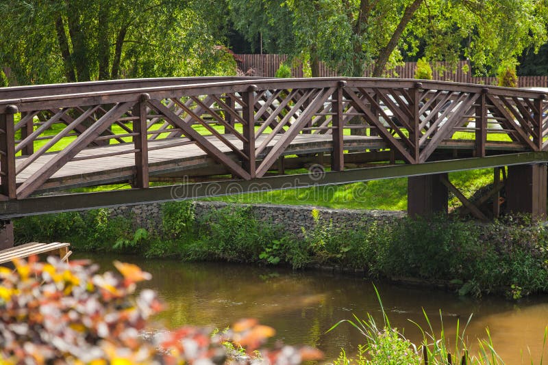 Wooden beautiful bridge over a pond in a country club in summer