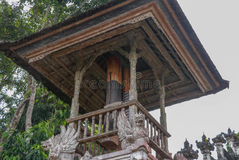 Wooden bell with a mallet made from a tree trunk. Bale Kulkul is building to hand up the traditional alarm for local Balinese royalty free stock photography
