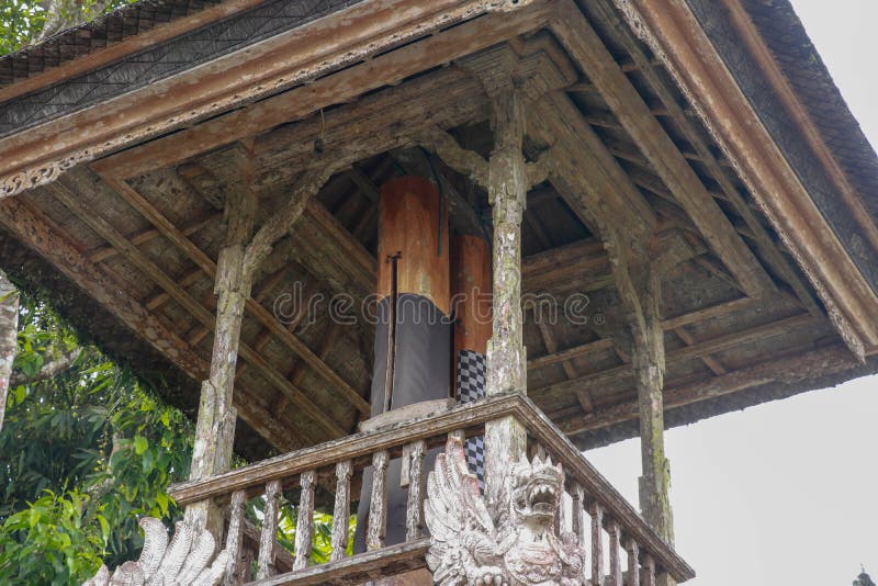 Wooden bell with a mallet made from a tree trunk. Bale Kulkul is building to hand up the traditional alarm for local Balinese stock images