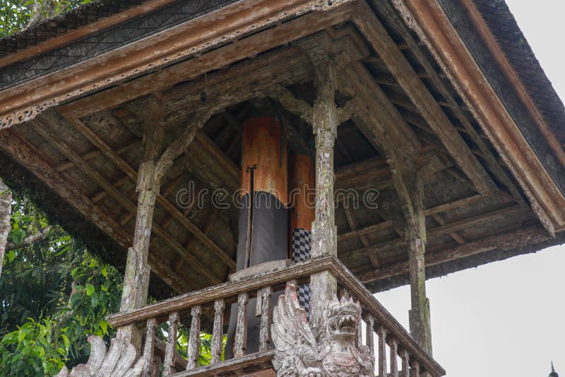 Wooden bell with a mallet made from a tree trunk. Bale Kulkul is building to hand up the traditional alarm for local Balinese royalty free stock photo