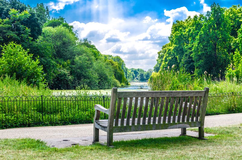 A wooden bench at St James`s Park in the summer