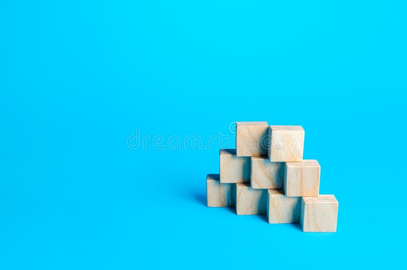 Wooden blocks pyramid on a blue background. Slide for presentation. Copy space, place for text. Steps. Minimalism. Simple shapes