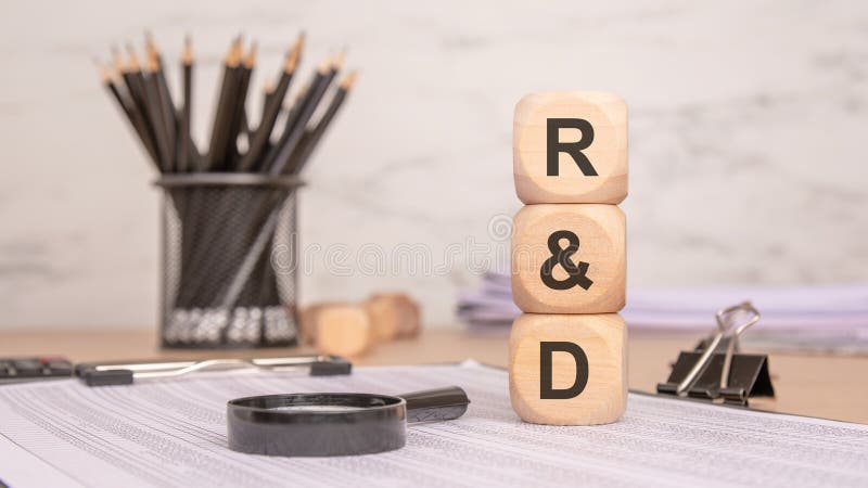 wooden blocks with R D on an office desk, symbolizing research and development