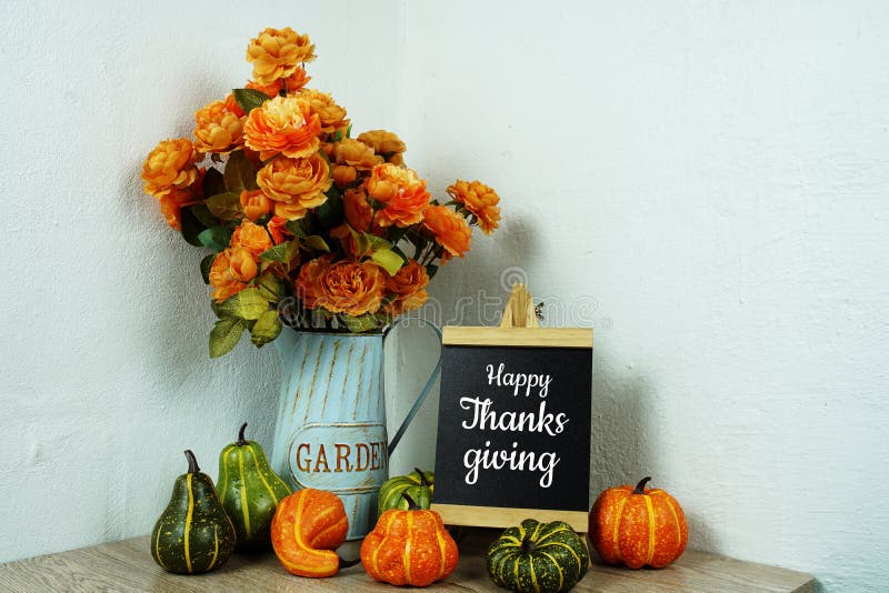 Happy Thanksgiving with Artificial flowers and pumpkin on wooden table interior decoration