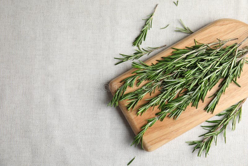 Wooden board with fresh rosemary twigs on fabric, top view. royalty free stock photography Wooden board with fresh rosemary twigs on fabric, top view. royalty free stock photography