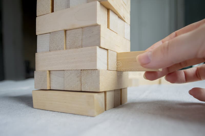 Wooden Board Game Tower. a Hand Pulls Out an Element from the Wooden