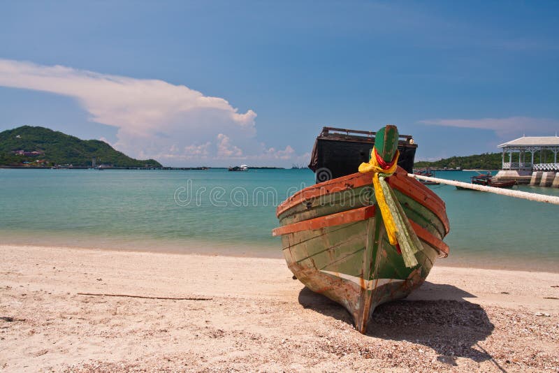 Wooden boat on the beach with blue sky from front