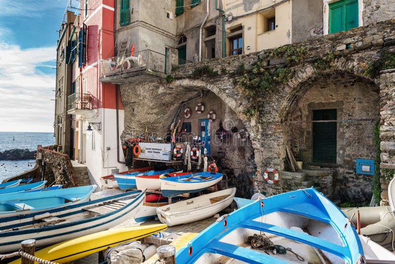 Wooden boats are moored at coast of Riomaggiore town in Cinque Terre National park, Italy