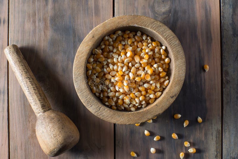 Wooden bowl full of popping corn kernals