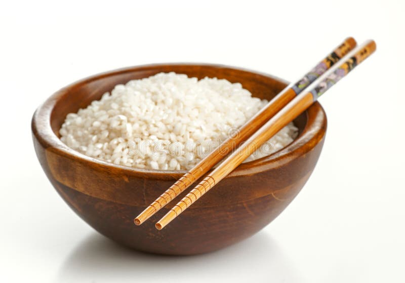 Wooden bowl with rice and Chinese chopsticks royalty free stock photo.