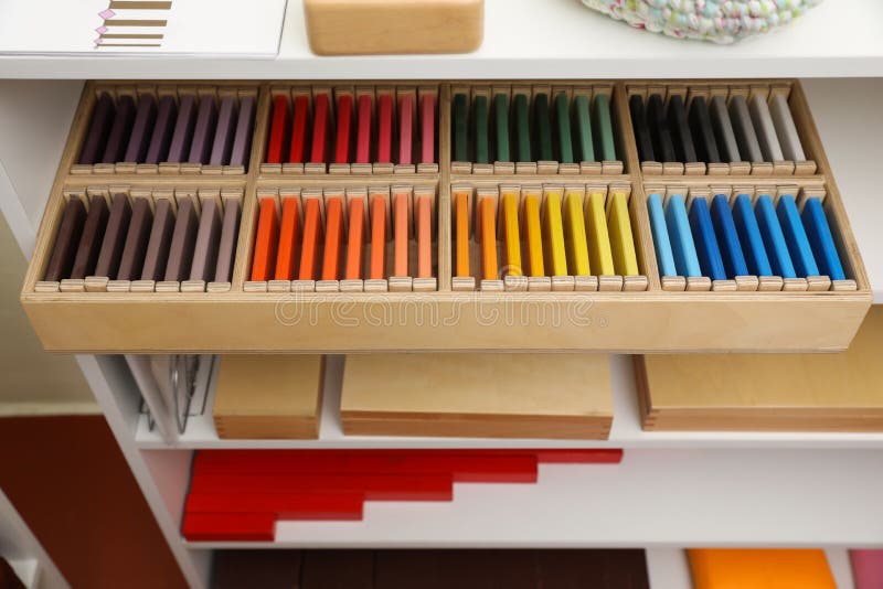 Wooden box with color tablets and other montessori toys on shelves