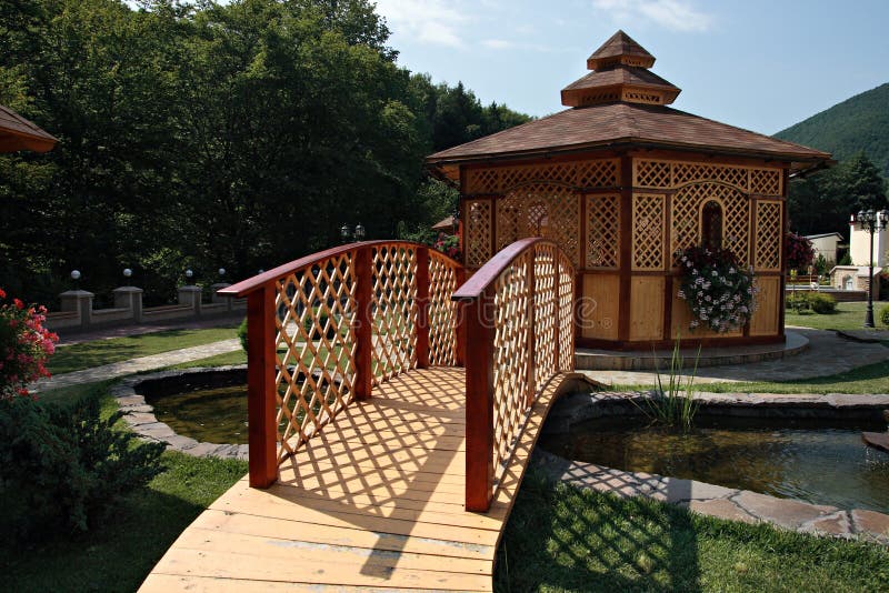 A summerhouse in a domestic garden in summer, with small bridge over the artificial lake. Boardwalk rail stock images, royalty-free photos and pictures