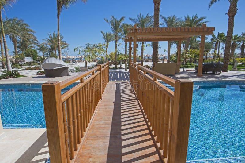 Wooden bridge over a swimming pool of luxury hotel resort room