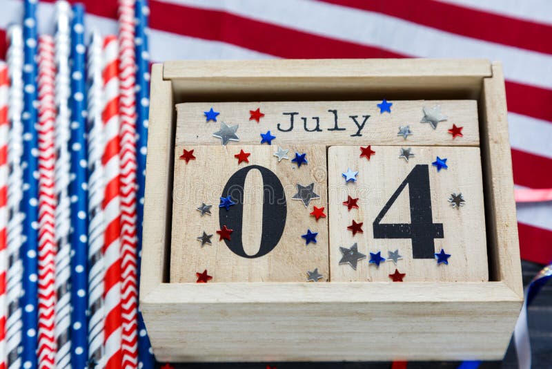 Wooden calendar 4th of July day of American independence, decorations, flag, candles, straws. USA holiday decorations royalty free stock photos Wooden calendar 4th of July day of American independence, decorations, flag, candles, straws. USA holiday decorations royalty free stock photos