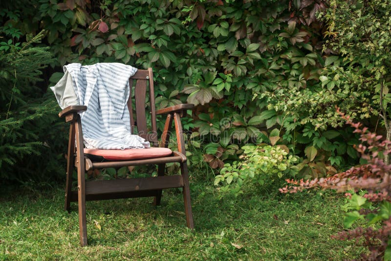 Wooden chair with plaid in cottage garden