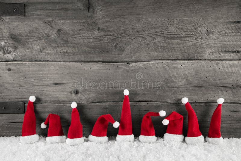 Dřevěná vánoční pozadí s červené santa klobouky na slavnostní rámec.