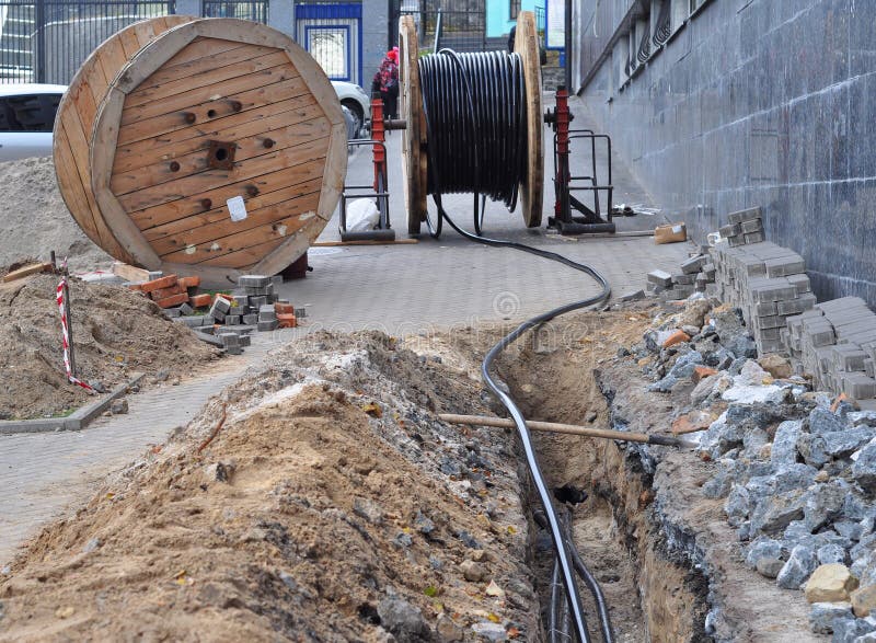 Wooden coil of electric cable and optical fibres in the digging on the street royalty free stock images Wooden coil of electric cable and optical fibres in the digging on the street royalty free stock images