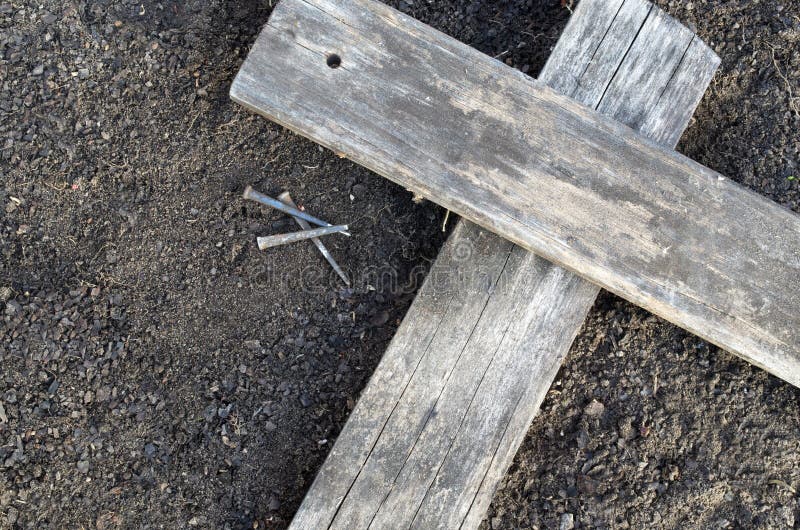 Wooden Cross With 3 Nails On The Ground