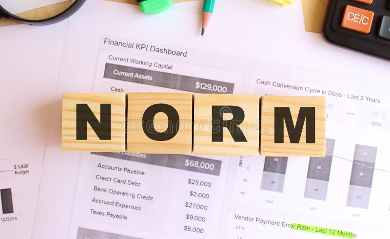 Wooden cubes with letters on the table in the office. Text NORM stock photography
