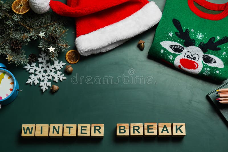 Wooden cubes with text Winter Break and Christmas decor on green background, flat lay. School holidays