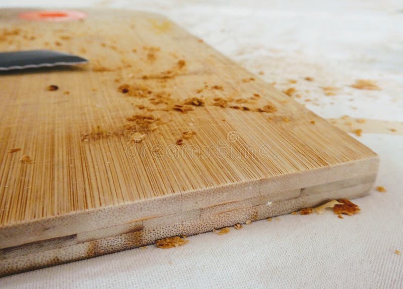 Bread Knife with Bread Crumbs on Wooden Cutting Plate. Stock Image
