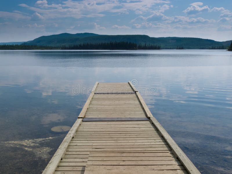 Wooden dock on a beautiful calm Yukon lake Canada royalty free stock image
