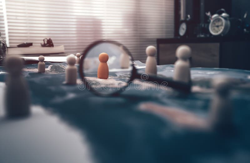 The wooden doll represents the employee of the company and magnifying glass view them represents the employee of the company on world map represents networking, connection. Search or find new job and Corporation, Enterprise concept.