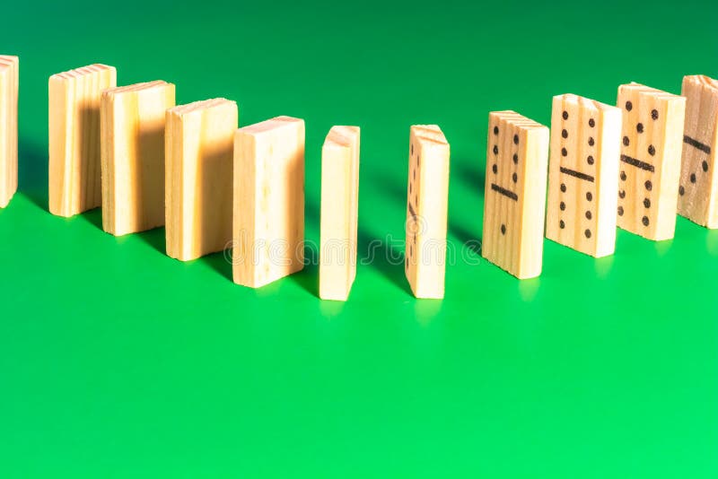 Wooden Dominoes Lined Up on Solid Green stock image