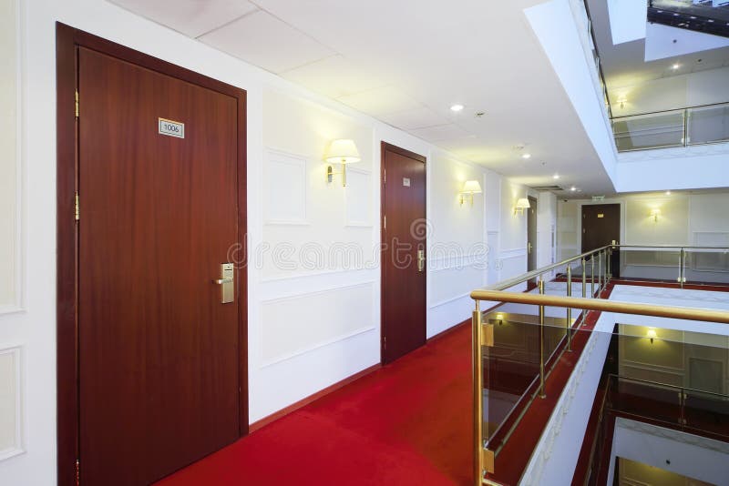 Wooden doors, red carpet on floor and handrails of balconies