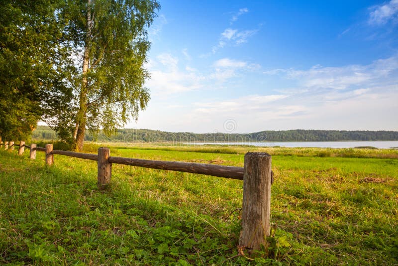 Wooden fence on the lake coast, Russian landscape